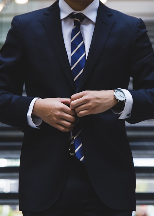 テーラードスーツを着た男性の手元と胸元のディテール